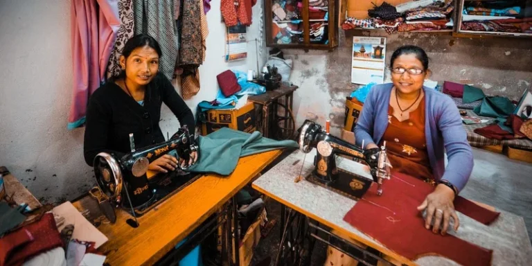 Two women dressmakers working with sewing machines in a vibrant workshop setting