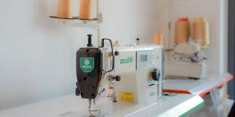 Close-up shot of a Zoje sewing machine in a bright, organized tailoring workshop