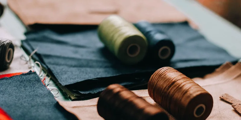 Vibrant spools of thread on various fabric pieces in a cozy workshop setting