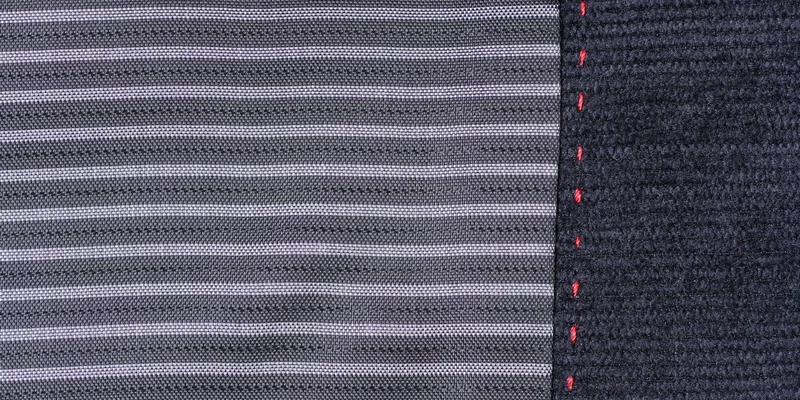 Detailed close-up of striped fabric featuring contrasting red stitching along the edge