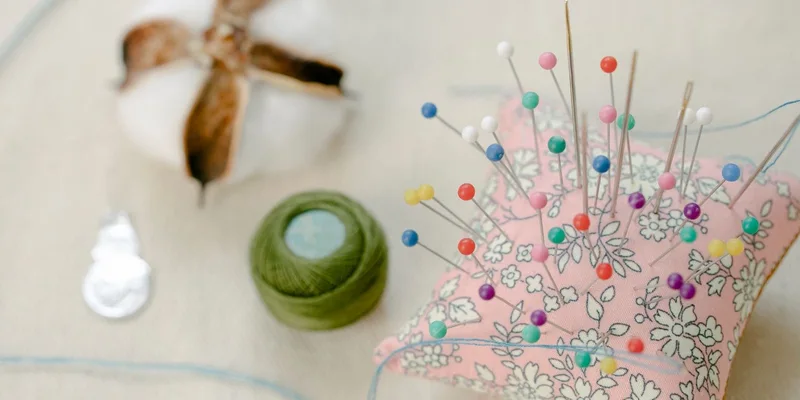 Colorful pins and threads on a sewing workspace