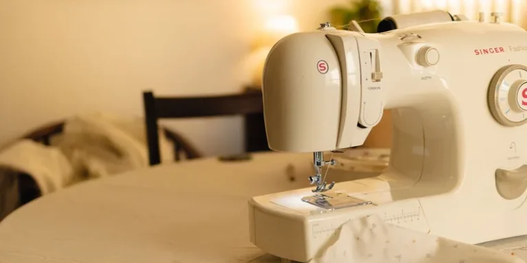 White sewing machine on a table in a cozy indoor setting, with soft lighting