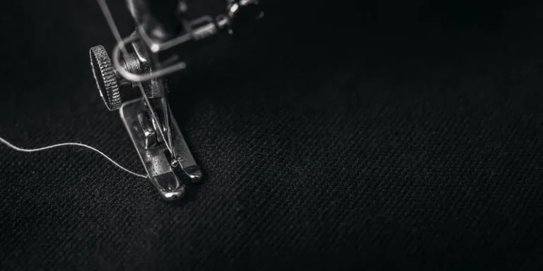 Detailed view of a sewing machine needle stitching fabric