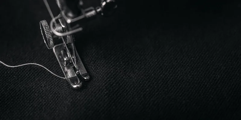 Detailed view of a sewing machine needle stitching fabric