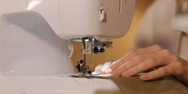 A detailed view of hands sewing fabric on a sewing machine