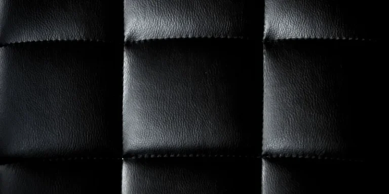 Detailed close-up of a black leather upholstery with a minimalist and modern texture