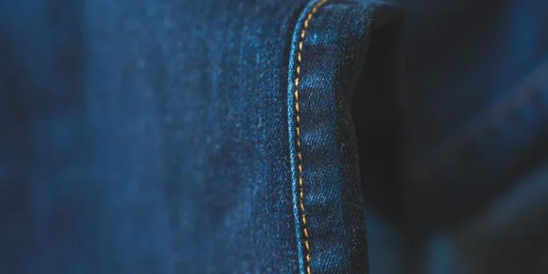 Detailed close-up of blue denim fabric showcasing intricate stitching