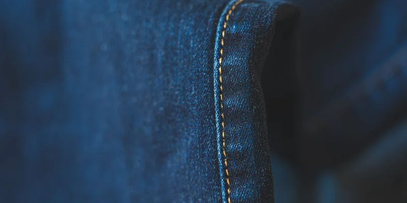 Detailed close-up of blue denim fabric showcasing intricate stitching