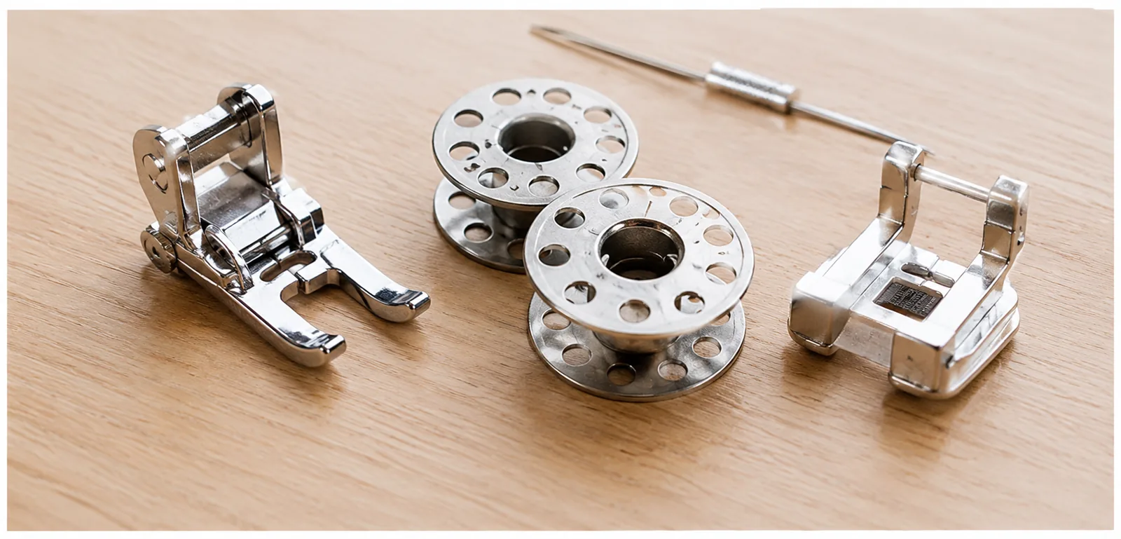 Presser feet and bobbins on a wooden table