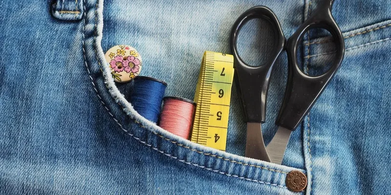 Sewing supplies in the pocket of a pair of jeans