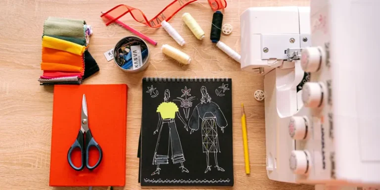 Flatlay with sketchbook, fabric swatches and a serger