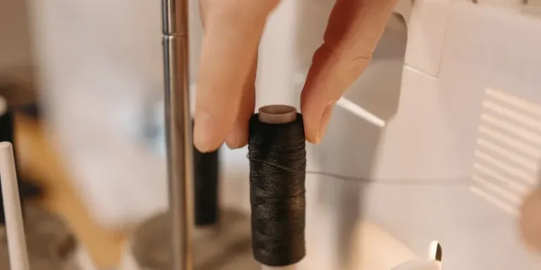 Hand placing a thread cone on a serger