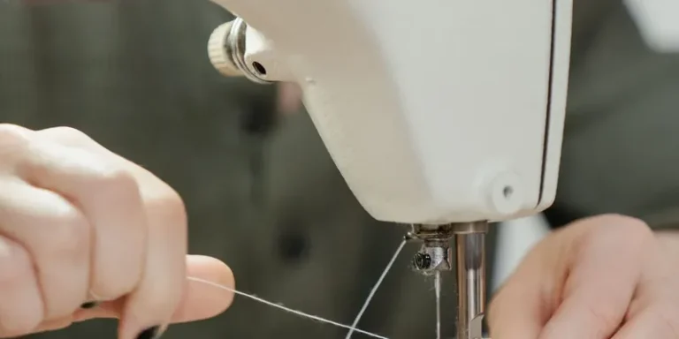 Hands threading the needle of a sewing machine