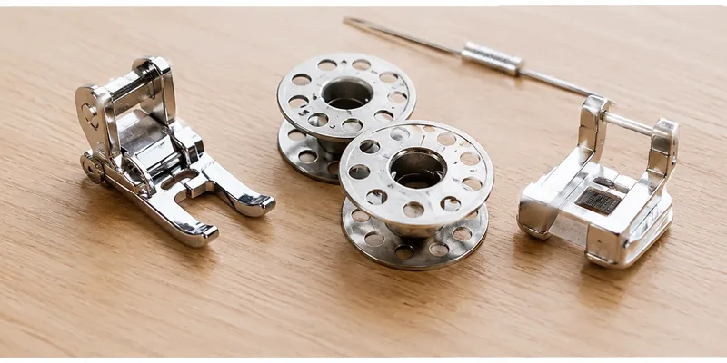 Presser feet and bobbins on a wooden table
