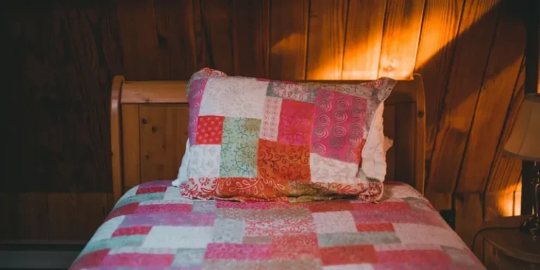 Pink patchwork bedspread and pillow on a bed