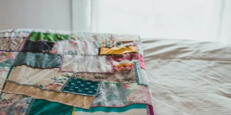 Patchwork quilt on a bed in warm colors
