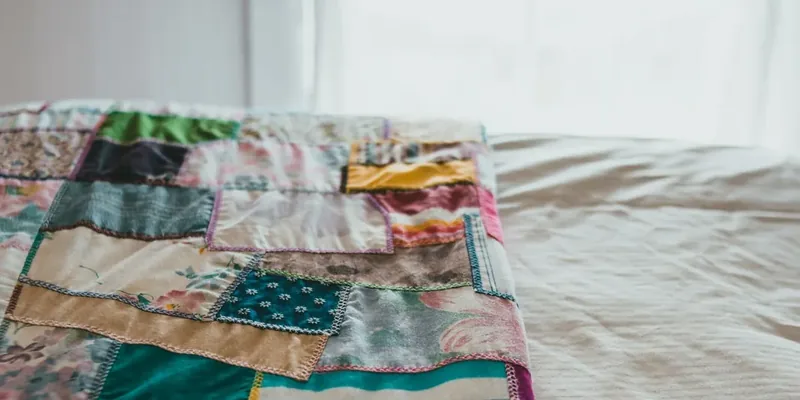 Patchwork quilt on a bed in warm colors