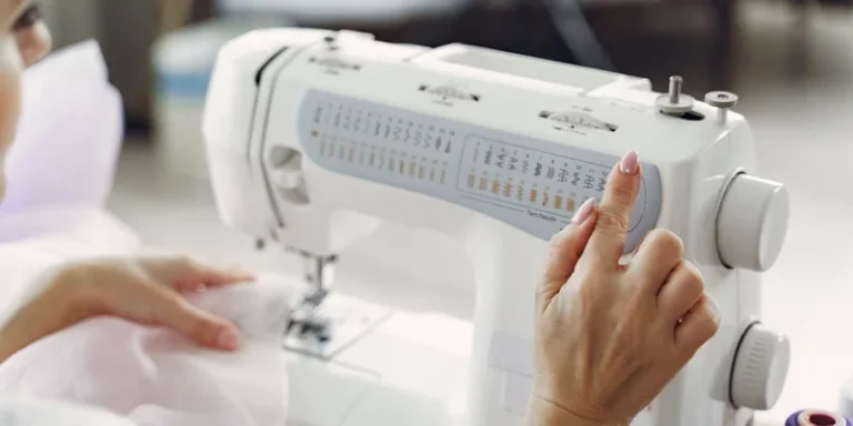 A person sewing with a white sewing machine, adjusting settings for precise tailoring