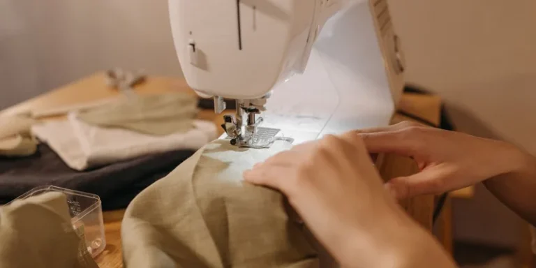 A close-up image of hands working with a sewing machine